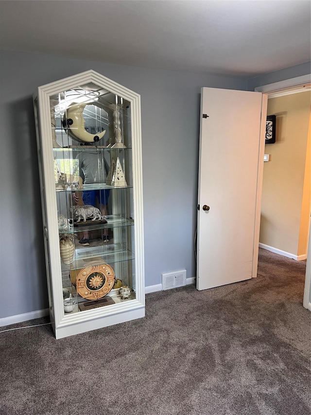 carpeted empty room featuring visible vents and baseboards