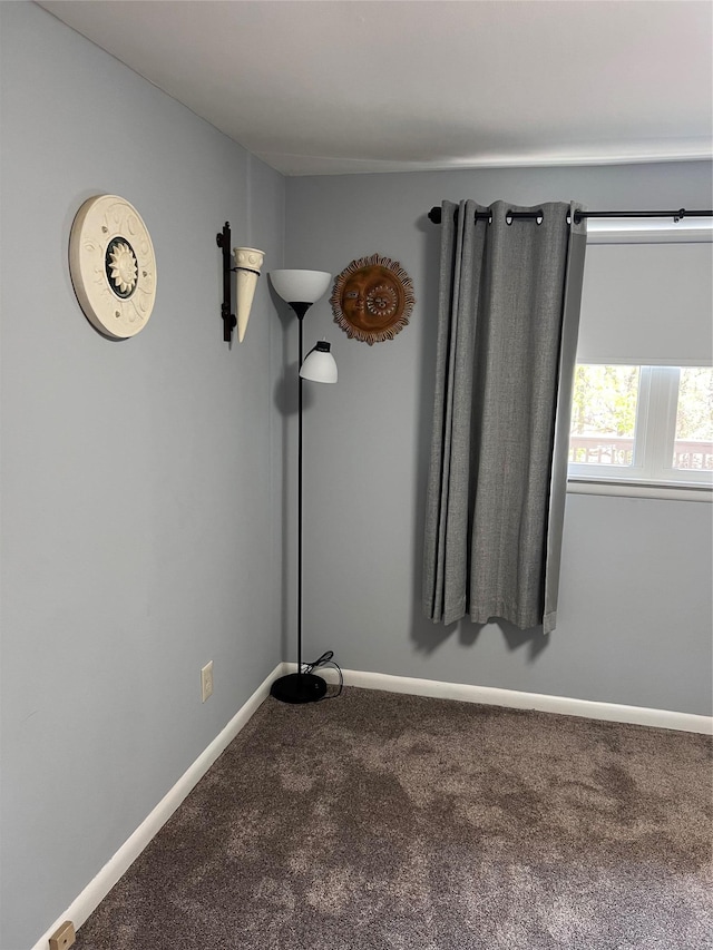 carpeted spare room featuring baseboards