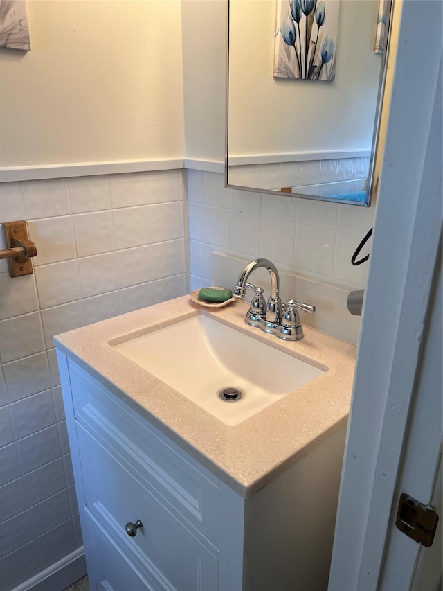 bathroom with vanity, decorative backsplash, and tile walls