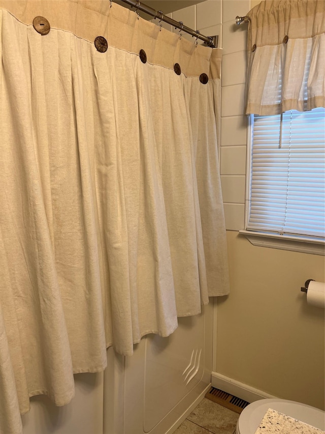 bathroom with baseboards, toilet, tile patterned floors, and visible vents