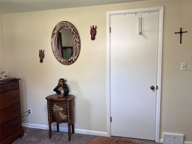 hallway featuring visible vents, carpet flooring, and baseboards
