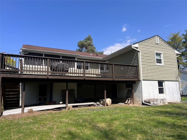 rear view of house featuring a lawn and a wooden deck