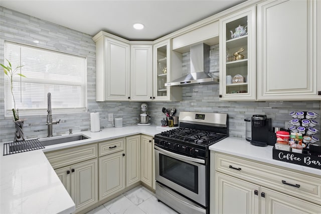 50 Darerka St, Amityville, NY 11701 - kitchen with stainless steel gas stove, wall chimney exhaust hood, a sink, decorative backsplash, and light marble finish floors