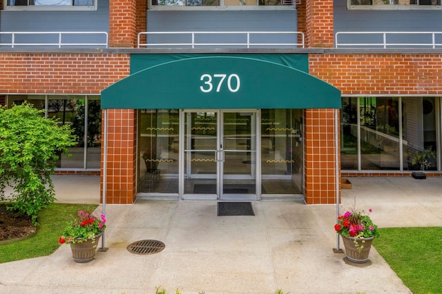 doorway to property featuring brick siding