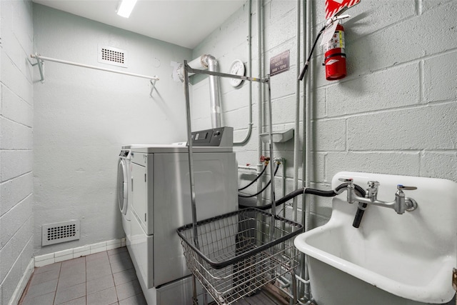 laundry area with washer and dryer, visible vents, tile patterned flooring, and a sink