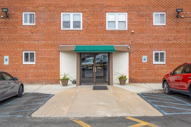 exterior space with brick siding and uncovered parking
