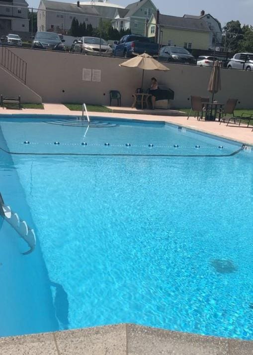 community pool featuring a residential view and fence