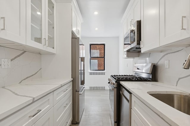 90 Park Ter E Unit 3G, New York Manhattan, NY 10034 - kitchen featuring a sink, white cabinets, stainless steel appliances, and tasteful backsplash