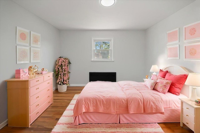 bedroom with baseboards and wood finished floors