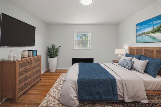 bedroom featuring baseboards and wood finished floors