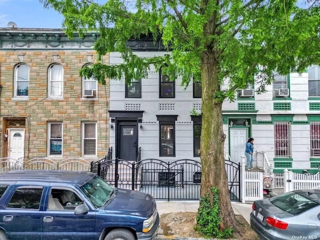 townhome / multi-family property featuring fence, a gate, and stone siding
