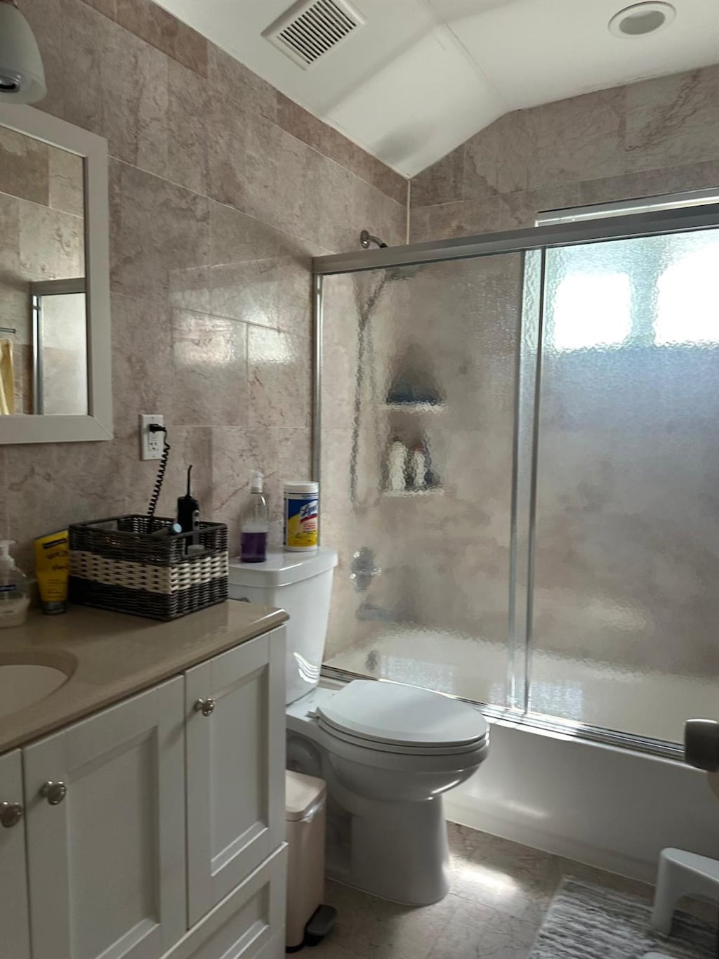 28 Glenda Dr, Deer Park, NY 11729 - full bath with tile walls, vanity, bath / shower combo with glass door, vaulted ceiling, and toilet