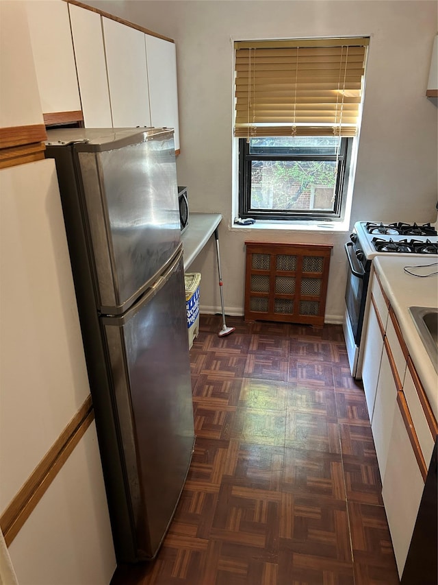 83-75 118th St Unit 4H, Kew Gardens, NY 11415 - kitchen with gas range oven, freestanding refrigerator, white cabinets, and light countertops