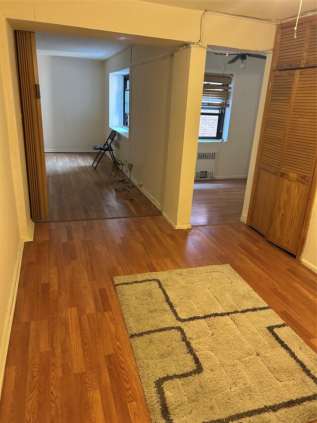 83-75 118th St Unit 4H, Kew Gardens, NY 11415 - corridor with wood finished floors, radiator, and healthy amount of natural light