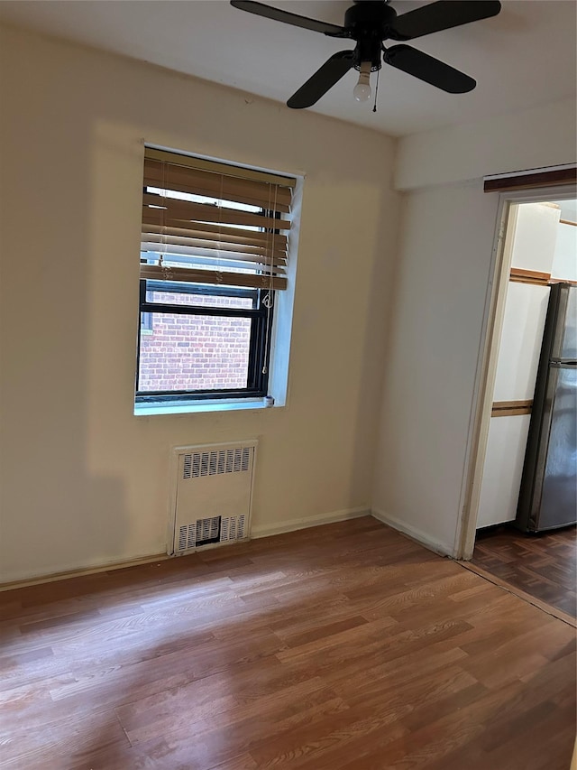 83-75 118th St Unit 4H, Kew Gardens, NY 11415 - spare room featuring radiator heating unit, ceiling fan, wood finished floors, and baseboards
