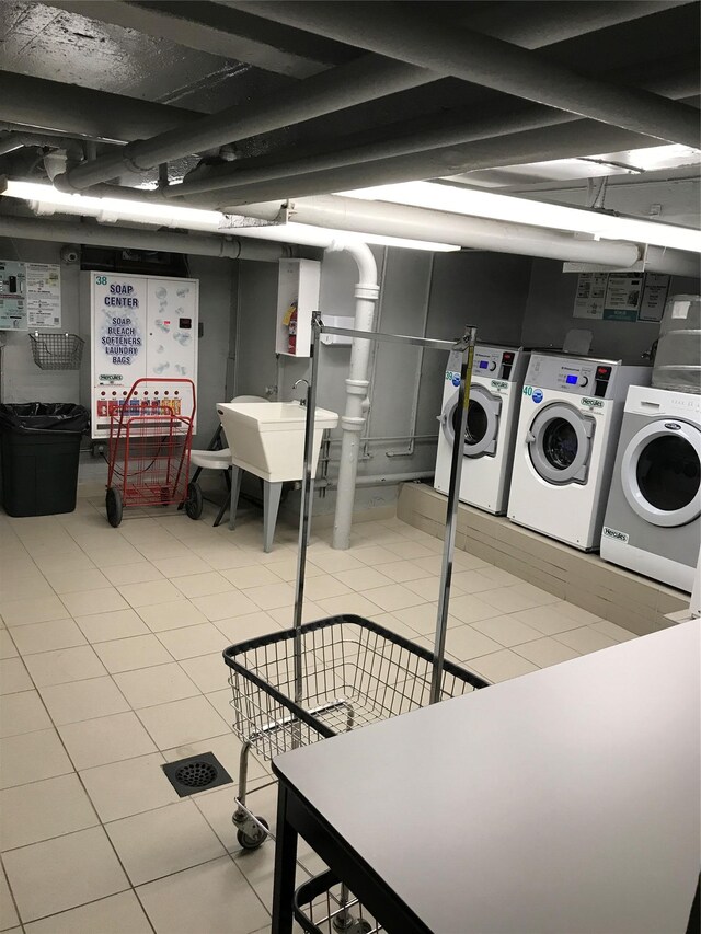 83-75 118th St Unit 4H, Kew Gardens, NY 11415 - washroom with a sink, independent washer and dryer, and light tile patterned floors