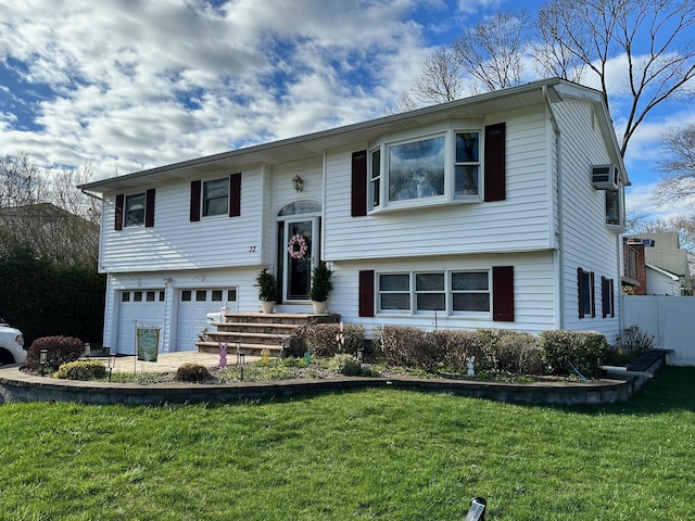33 41st St, Islip, NY 11751 - bi-level home with an attached garage, fence, driveway, and a front yard