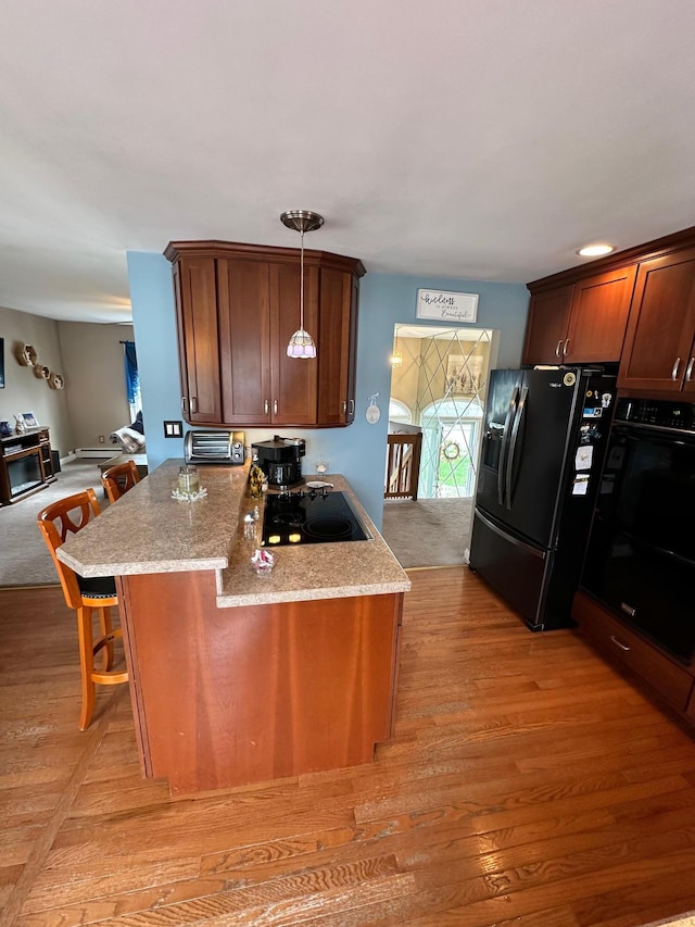 33 41st St, Islip, NY 11751 - kitchen featuring a kitchen breakfast bar, light wood-type flooring, a toaster, light stone counters, and black appliances