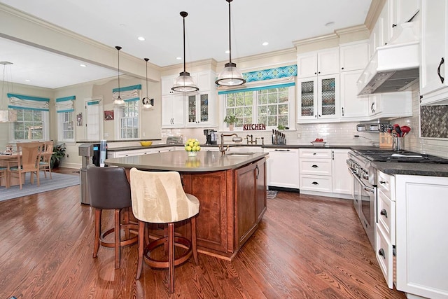 kitchen featuring decorative backsplash, dark wood-style floors, dark countertops, and glass insert cabinets
