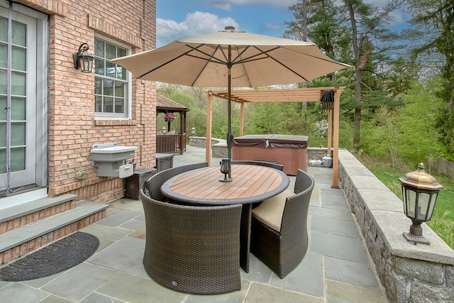 view of patio featuring entry steps, outdoor dining area, and a hot tub