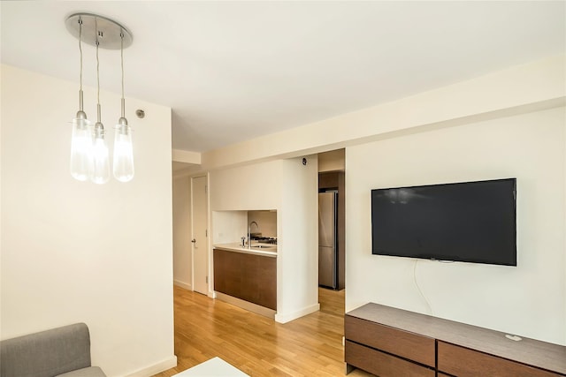 living room with baseboards and light wood-style flooring
