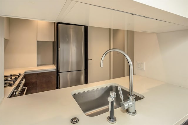 details with light countertops, a sink, and appliances with stainless steel finishes