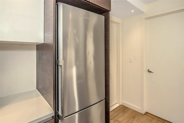 interior space with light wood-style floors, light countertops, freestanding refrigerator, and recessed lighting
