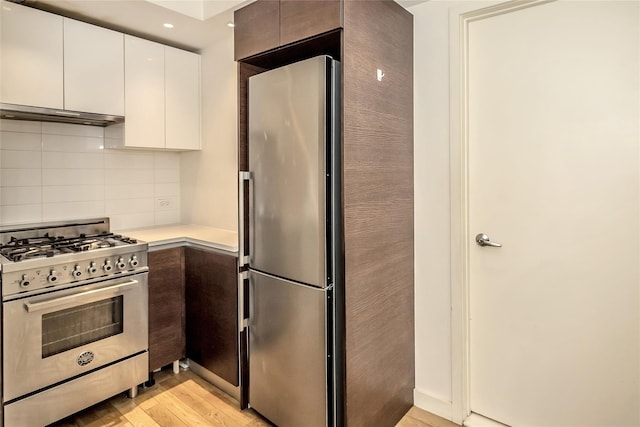kitchen featuring light wood-style floors, light countertops, stainless steel appliances, white cabinetry, and tasteful backsplash