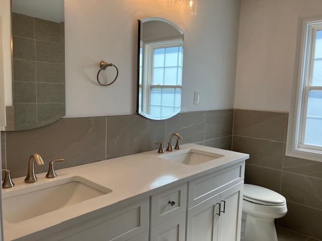 267 N Elm St, Massapequa, NY 11758 - full bath with tile walls, double vanity, and toilet