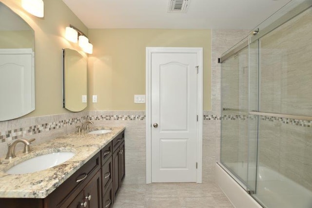 267 N Elm St, Massapequa, NY 11758 - full bath featuring tile walls, enclosed tub / shower combo, double vanity, and a wainscoted wall