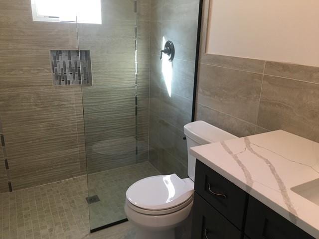 267 N Elm St, Massapequa, NY 11758 - full bath with vanity, toilet, a stall shower, and tile walls