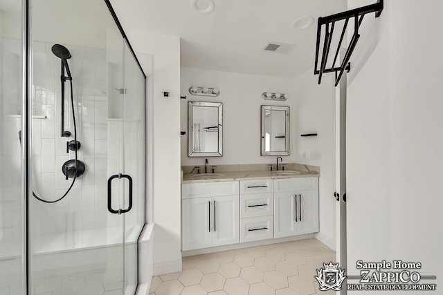 bathroom featuring double vanity, visible vents, a stall shower, and a sink