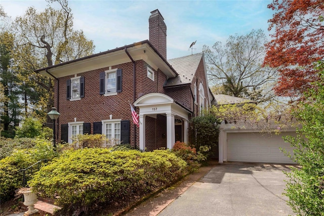 157 Alta Ave, Yonkers, NY 10705 - colonial-style house featuring a chimney, driveway, brick siding, and an attached garage