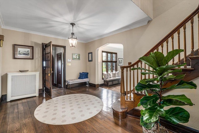 foyer entrance featuring stairs, wood-type flooring, arched walkways, and radiator heating unit