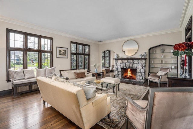 living area with wood-type flooring, a fireplace, and ornamental molding