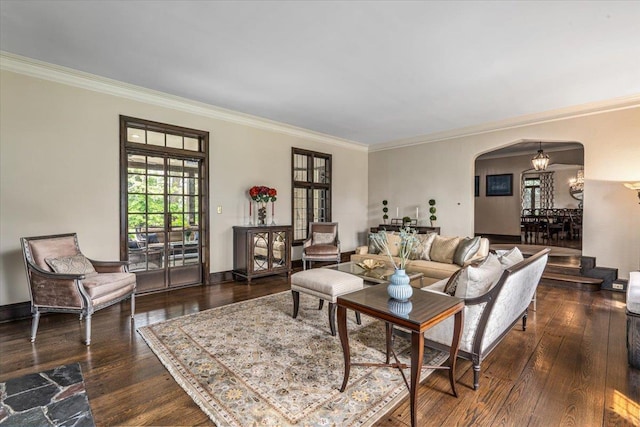 living room featuring arched walkways, an inviting chandelier, crown molding, and hardwood / wood-style flooring