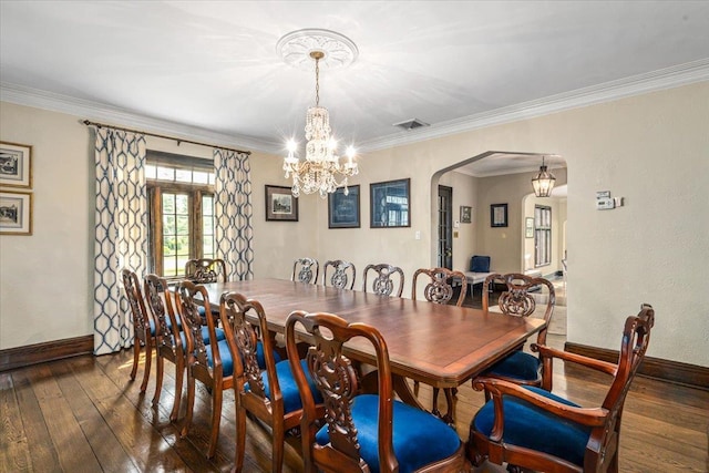 dining room with arched walkways, baseboards, a chandelier, and wood-type flooring