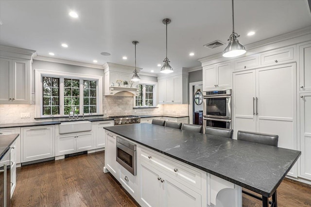 kitchen with white cabinetry, visible vents, appliances with stainless steel finishes, and a sink