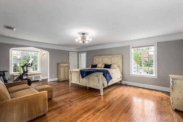 bedroom featuring baseboards, multiple windows, a chandelier, and visible vents