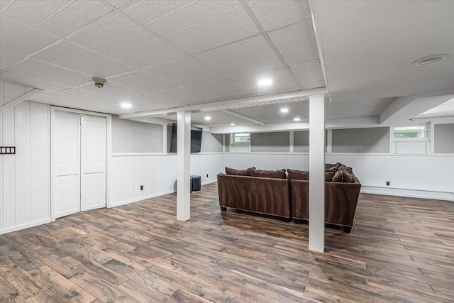 basement with a decorative wall and wood finished floors