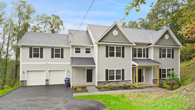 view of front of property featuring stone siding, roof with shingles, an attached garage, and aphalt driveway