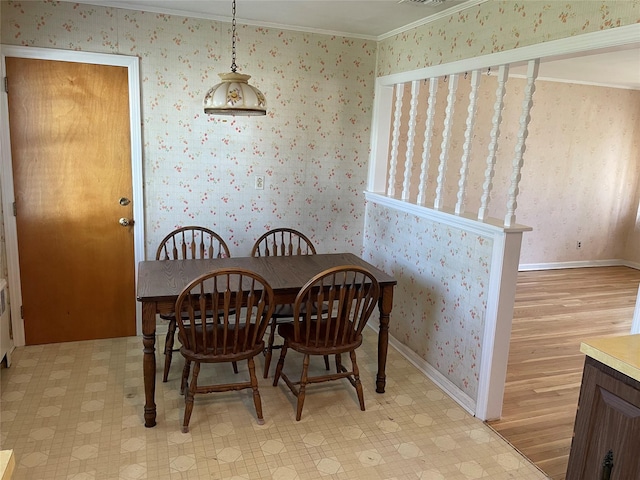 dining area featuring wallpapered walls, light floors, ornamental molding, and baseboards