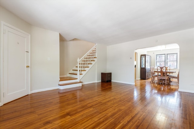 150-20 77th Ave, Kew Garden Hills, NY 11367 - unfurnished living room with baseboards, arched walkways, stairs, and wood finished floors