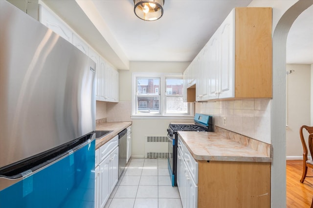 150-20 77th Ave, Kew Garden Hills, NY 11367 - kitchen featuring light countertops, white cabinetry, arched walkways, and appliances with stainless steel finishes