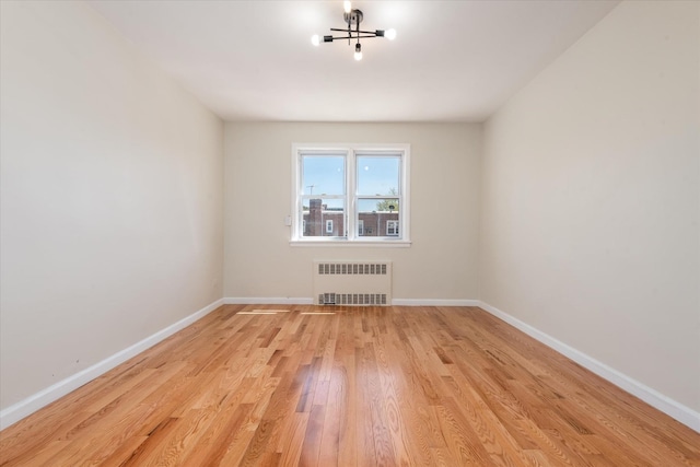 150-20 77th Ave, Kew Garden Hills, NY 11367 - empty room with baseboards, a notable chandelier, radiator heating unit, and light wood-type flooring