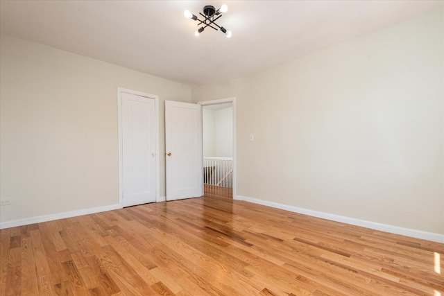 150-20 77th Ave, Kew Garden Hills, NY 11367 - spare room featuring light wood-type flooring, baseboards, and a chandelier
