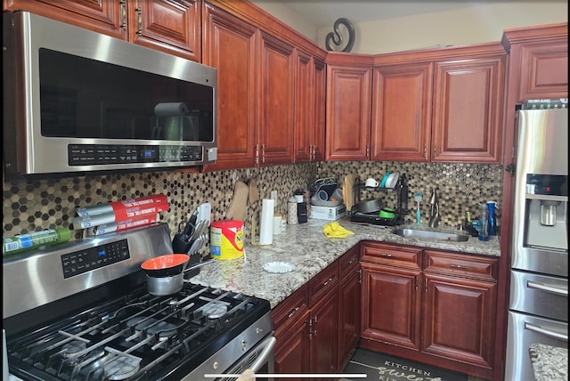 30 Mindres Ave, Brentwood, NY 11717 - kitchen with stainless steel appliances, light stone countertops, a sink, and tasteful backsplash