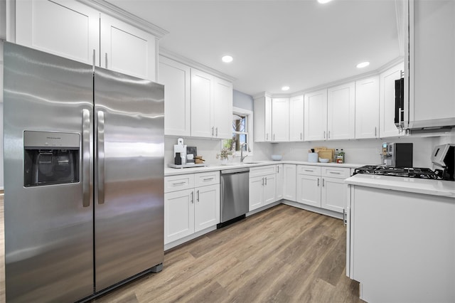 kitchen with white cabinets, stainless steel appliances, and light wood-style floors
