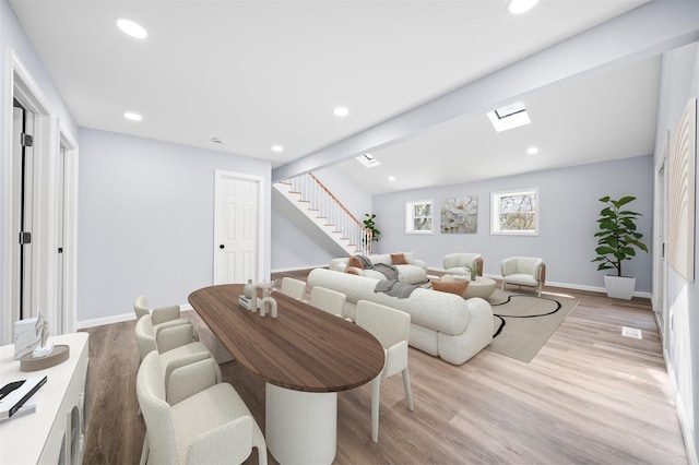 living area with recessed lighting, baseboards, light wood-style flooring, and stairway