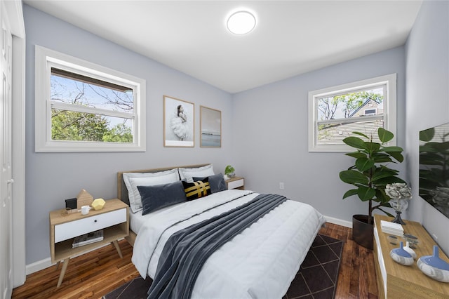 bedroom with baseboards and dark wood finished floors